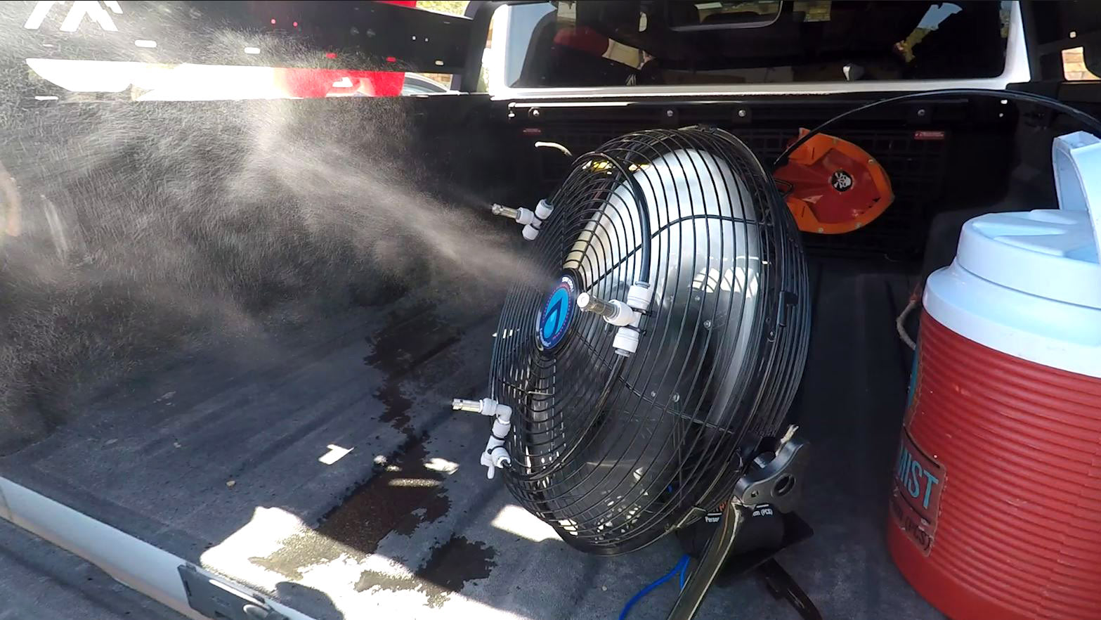 portable misting fan and water cooler on truck bed