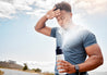 man sweating outside cooling off with misting water bottle spraying mist out of cap