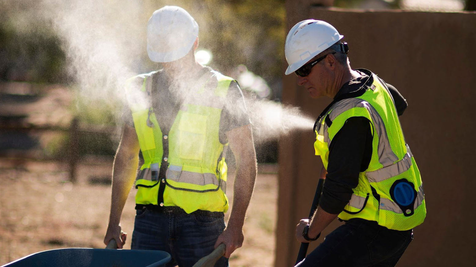 road workers wearing hi vis misting vests outside in hot weather