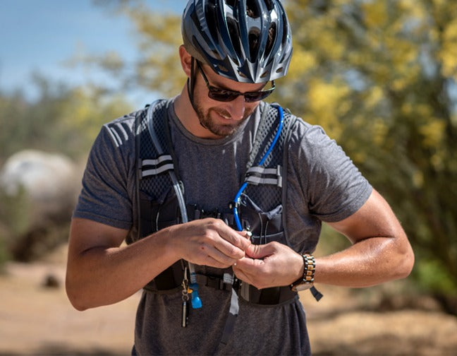 biker adjusting mist nozzle on misting hydration backpack