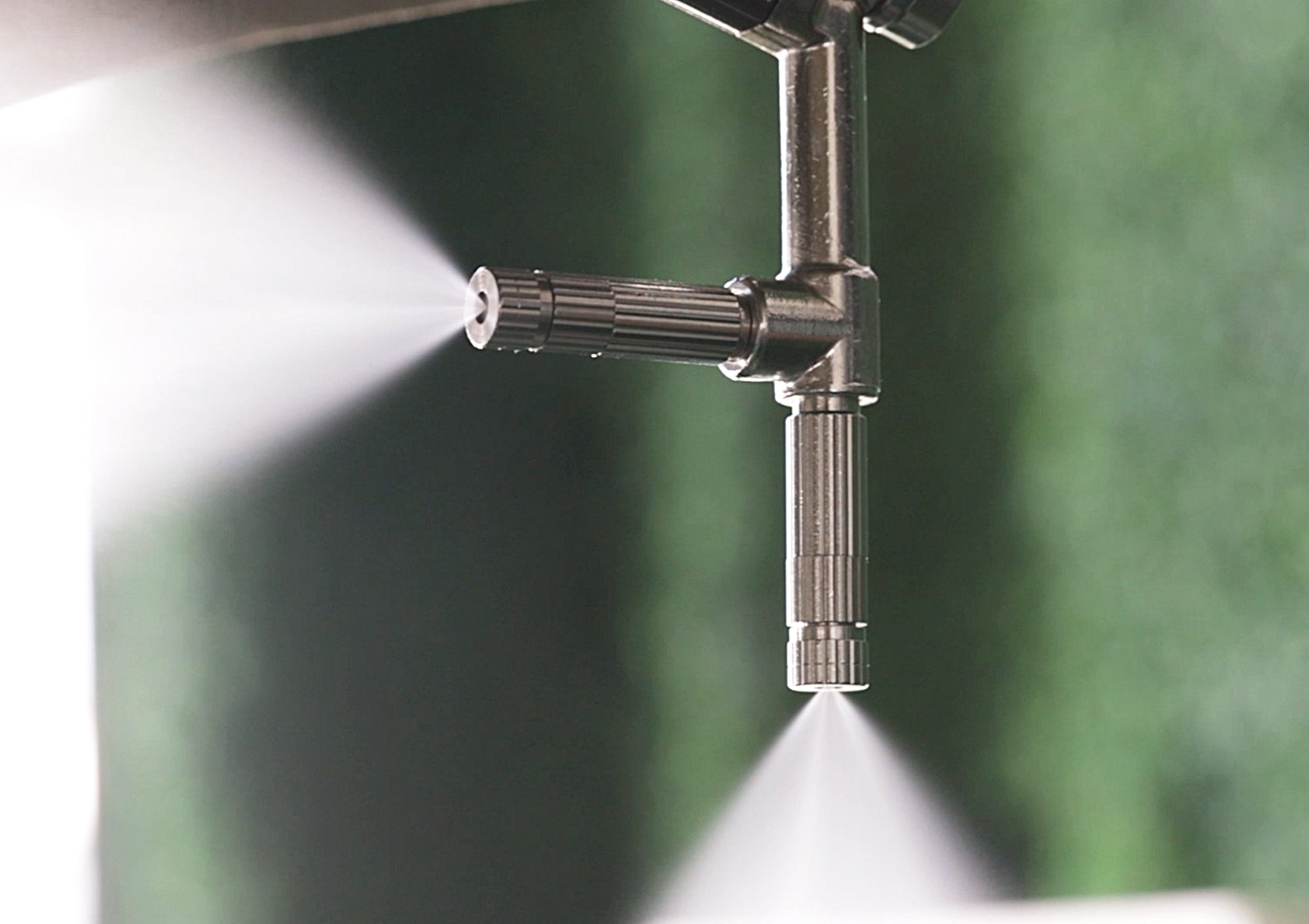 closeup of mist nozzles on misting umbrella spraying mist