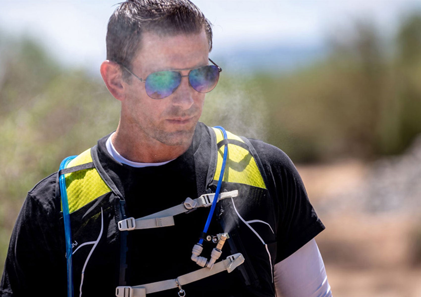 hiker outside wearing sunglasses wearing misting vest