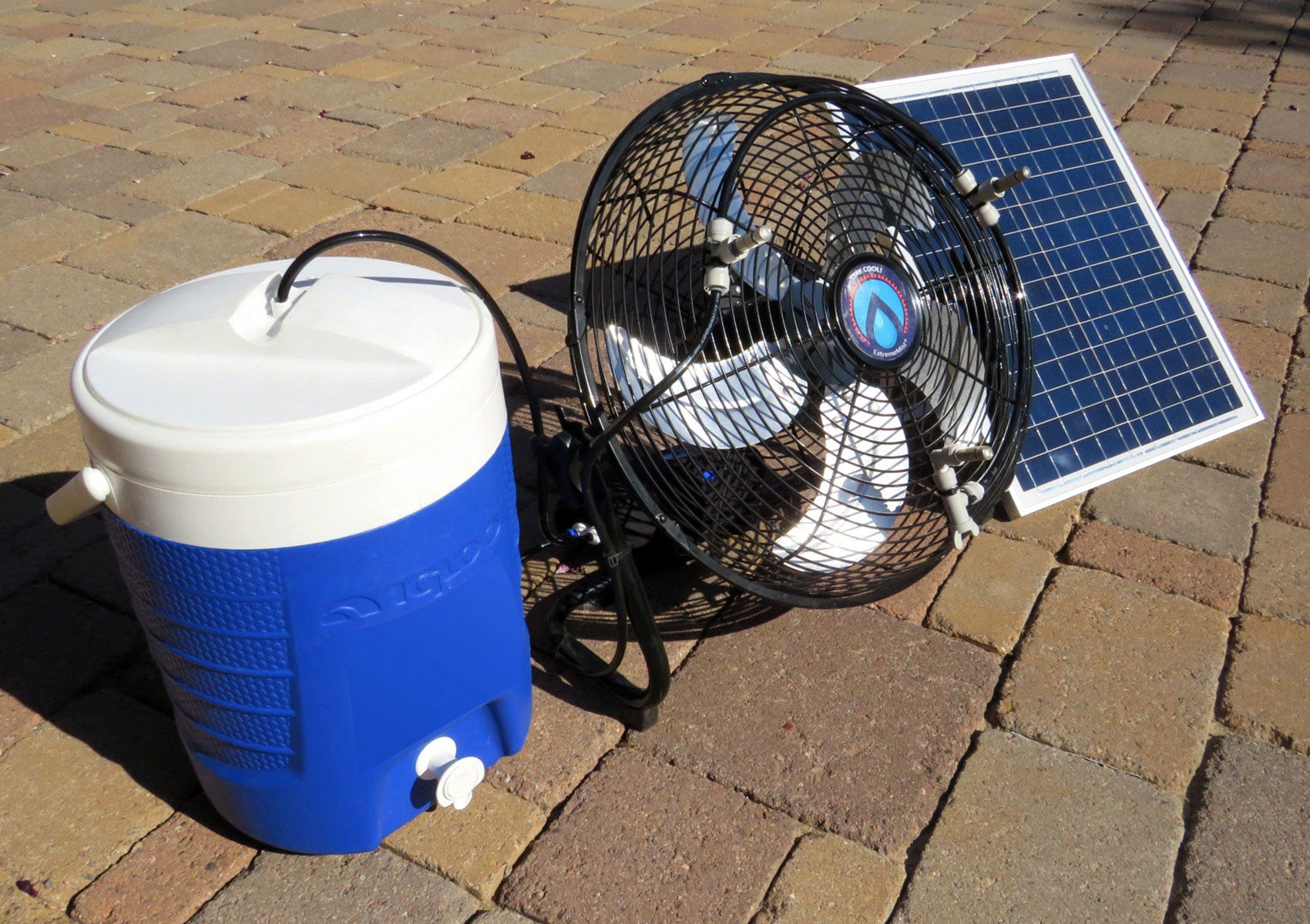 portable misting fan with solar panel and water cooler on pavers